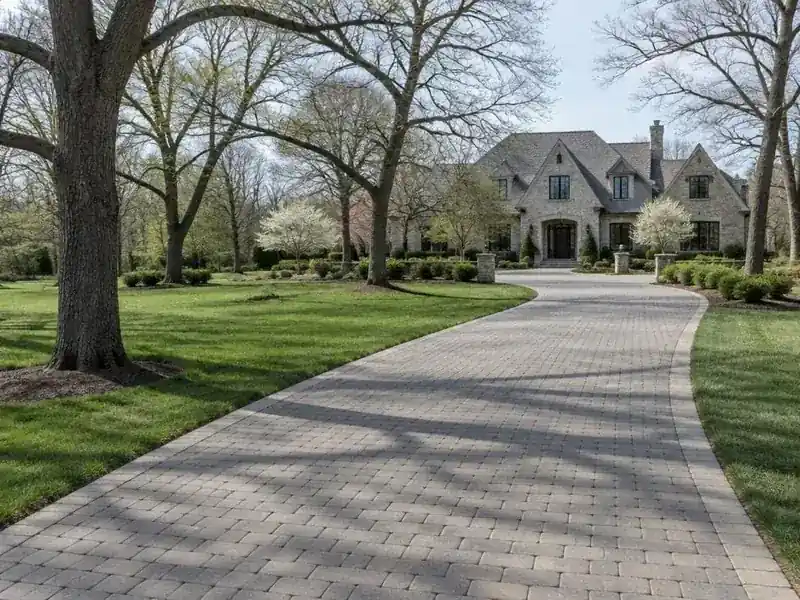 Clean paver driveway curving up to a large home in Barrington Hills, IL
